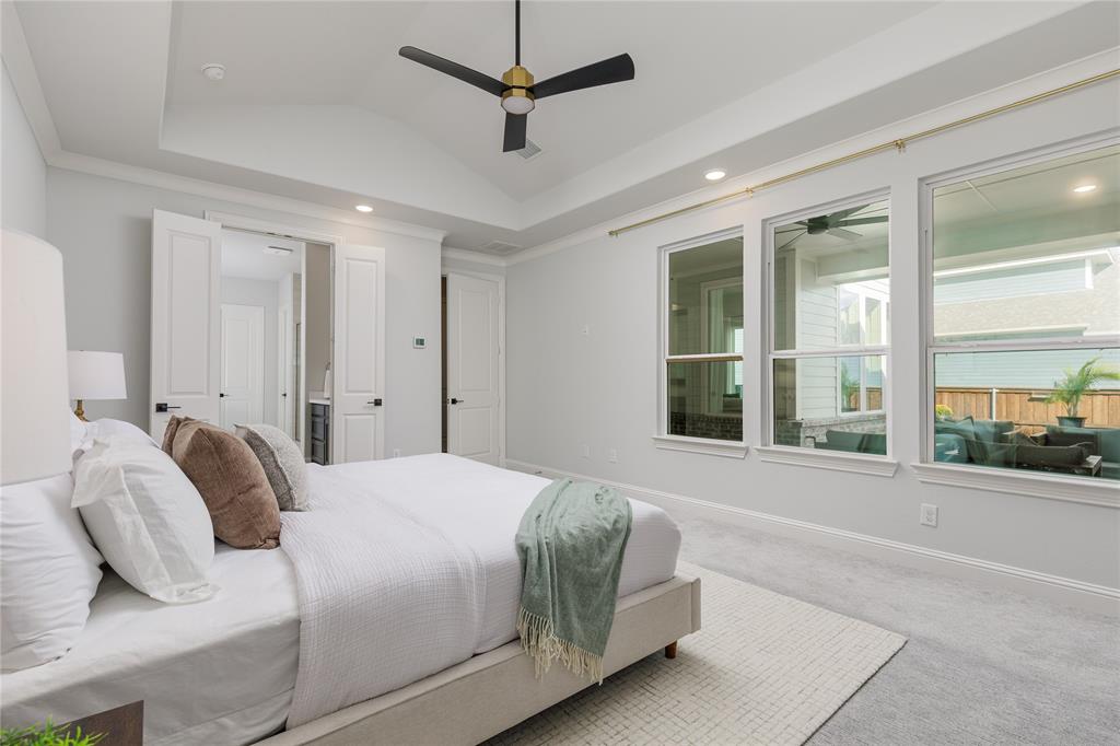 7409 Cormac Street McKinney, TX 75071 - Photo 16 of 40 Primary bedroom overlooks the backyard covered patio and pool.