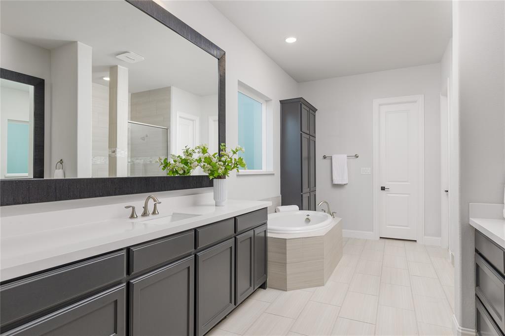 7409 Cormac Street McKinney, TX 75071 - Photo 18 of 40 Primary bathroom with dual vanities, soaking tub, and separate shower.