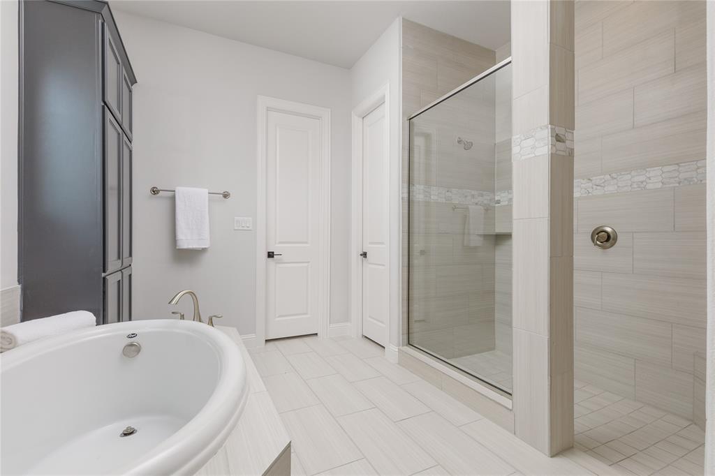 7409 Cormac Street McKinney, TX 75071 - Photo 20 of 40 Primary bathroom with dual vanities, soaking tub, and separate shower.