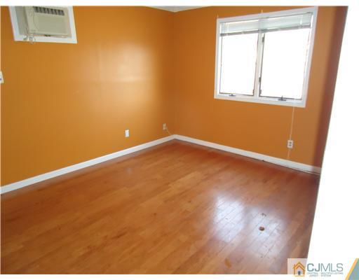 12 Crescent Road Edison, NJ 08817 - Photo 7 of 11 an empty room with wooden floor and windows