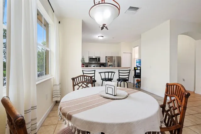 a kitchen with stainless steel appliances granite countertop a dining table and chairs