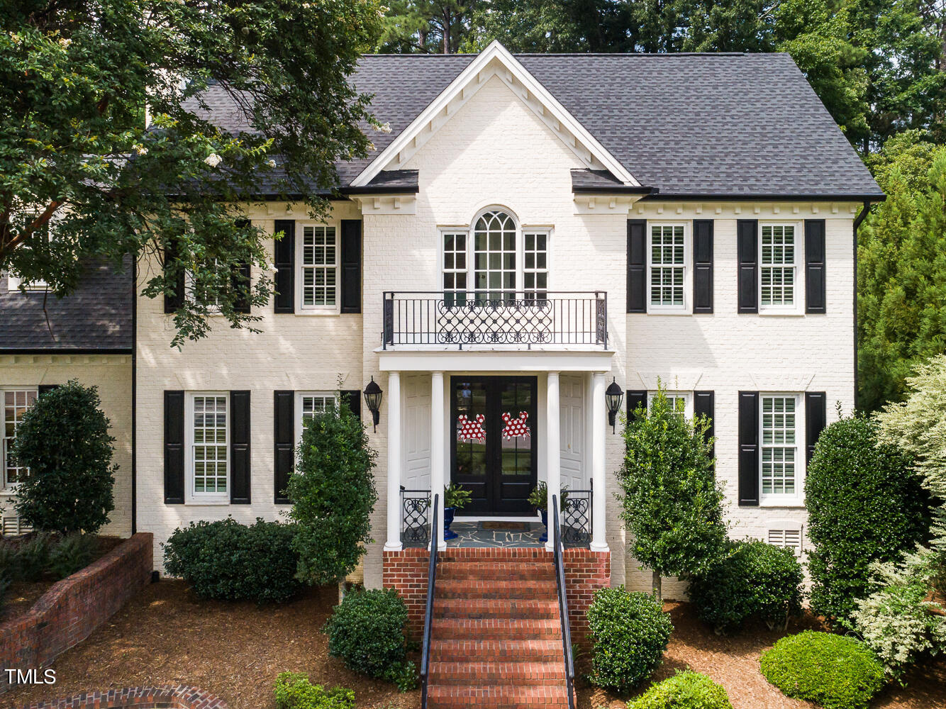 7404 Wingfoot Drive Raleigh, NC 27615 - Photo 3 of 61 a view of a white house next to a yard with potted plants and large trees