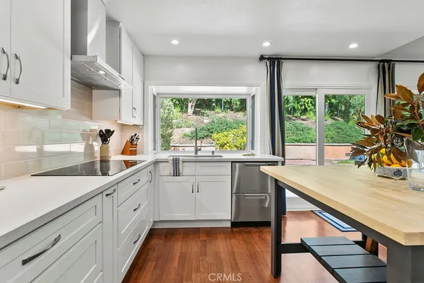 a kitchen with a sink a large window appliances and cabinets