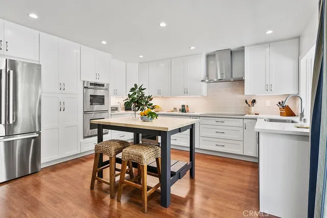 a kitchen with a table chairs refrigerator and microwave