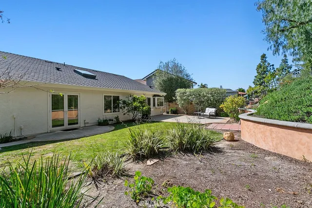 a view of a house with backyard and sitting area