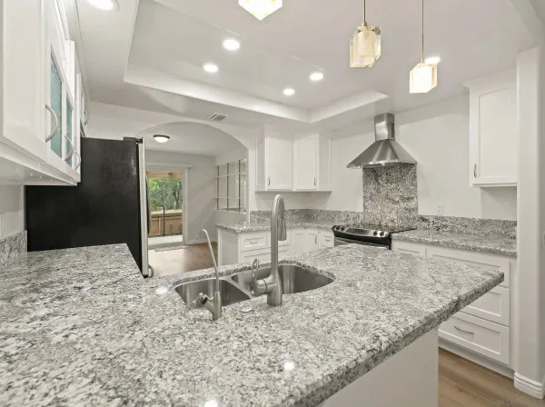 a kitchen with stainless steel appliances granite countertop a sink a stove counter space and cabinets