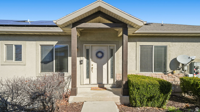 Front door, solar panels, and stucco siding