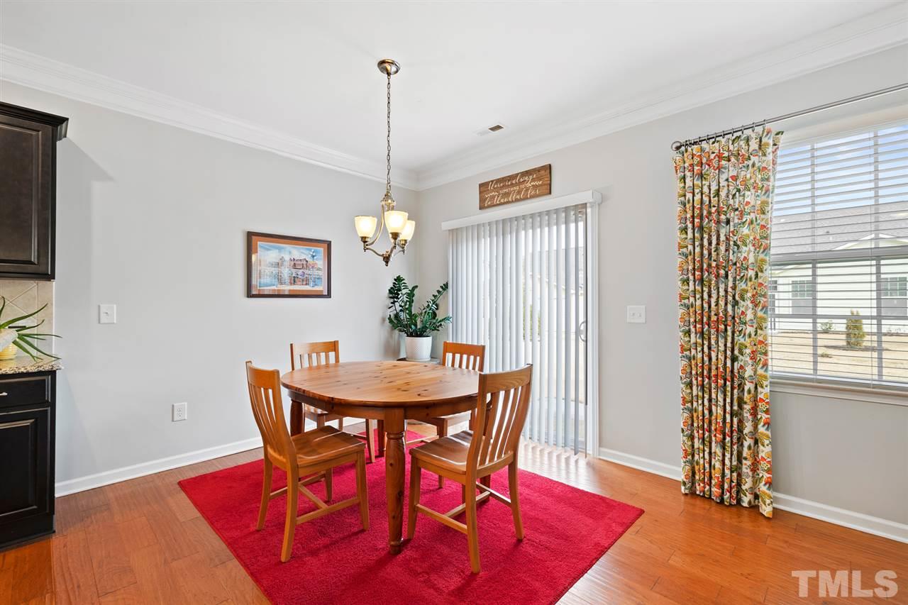 1013 Traditions Meadow Drive Wake Forest, NC 27587 - Photo 12 of 30 a view of a dining room with furniture window and wooden floor
