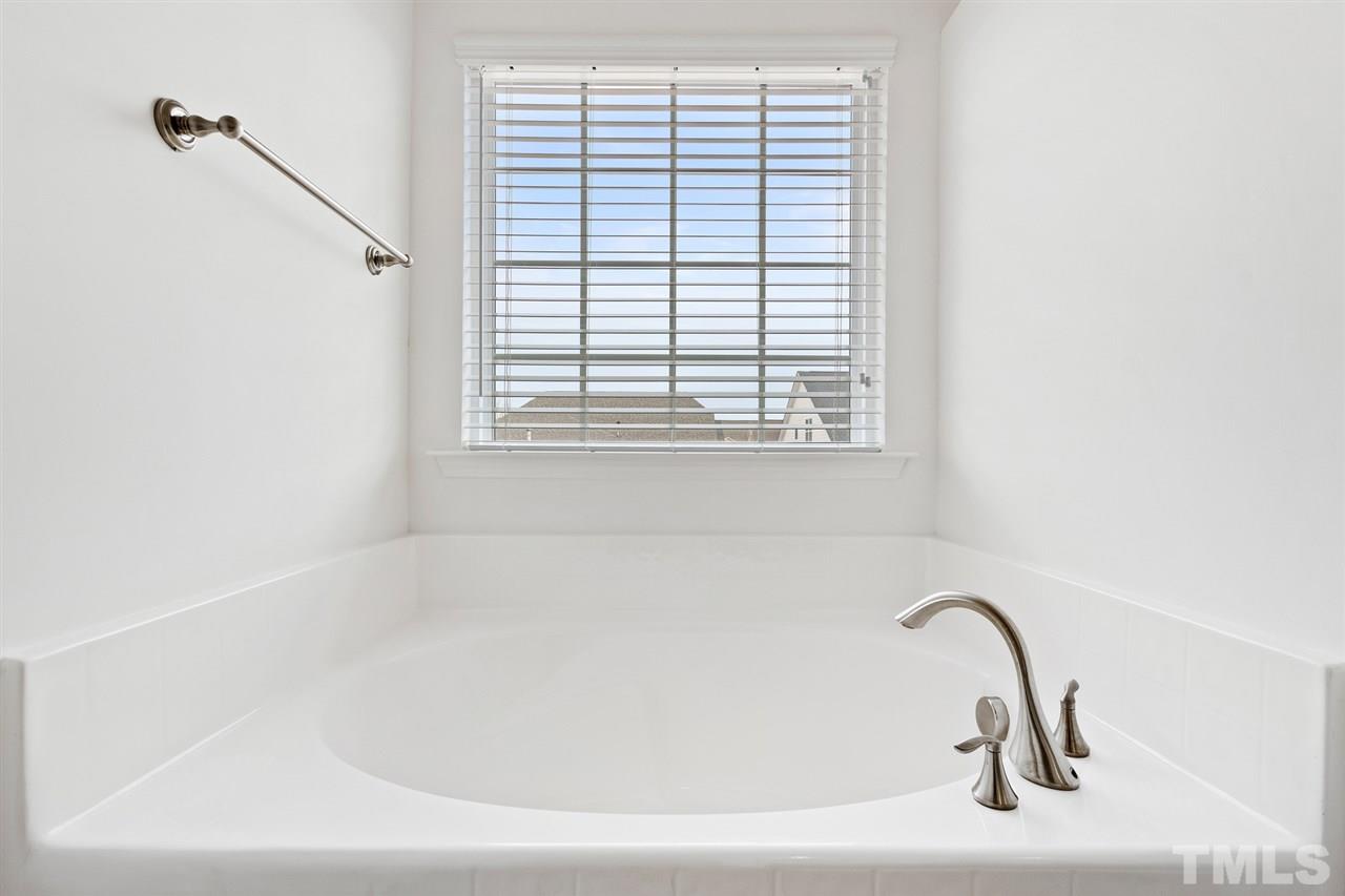 1013 Traditions Meadow Drive Wake Forest, NC 27587 - Photo 18 of 30 a bathroom with a bathtub and a window