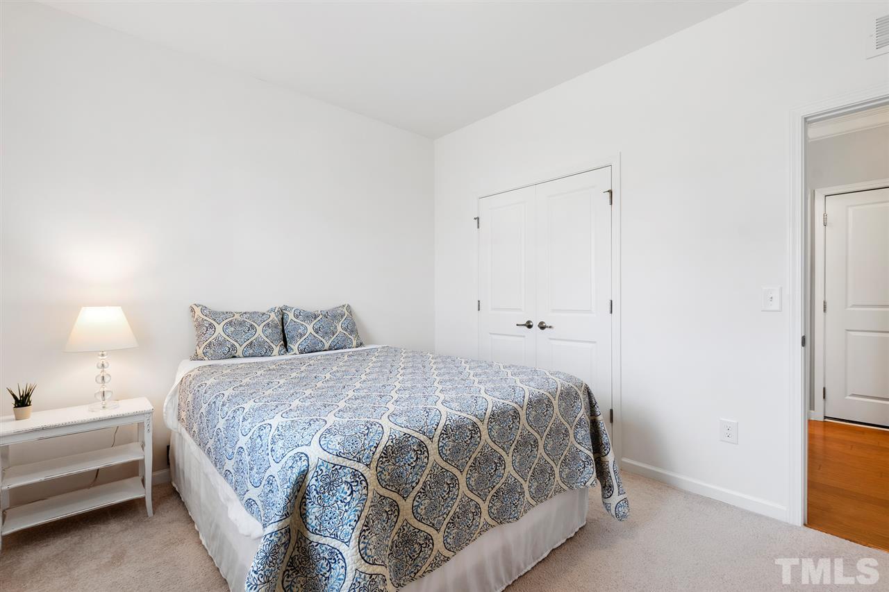 1013 Traditions Meadow Drive Wake Forest, NC 27587 - Photo 23 of 30 a bedroom with a bed and a lamp