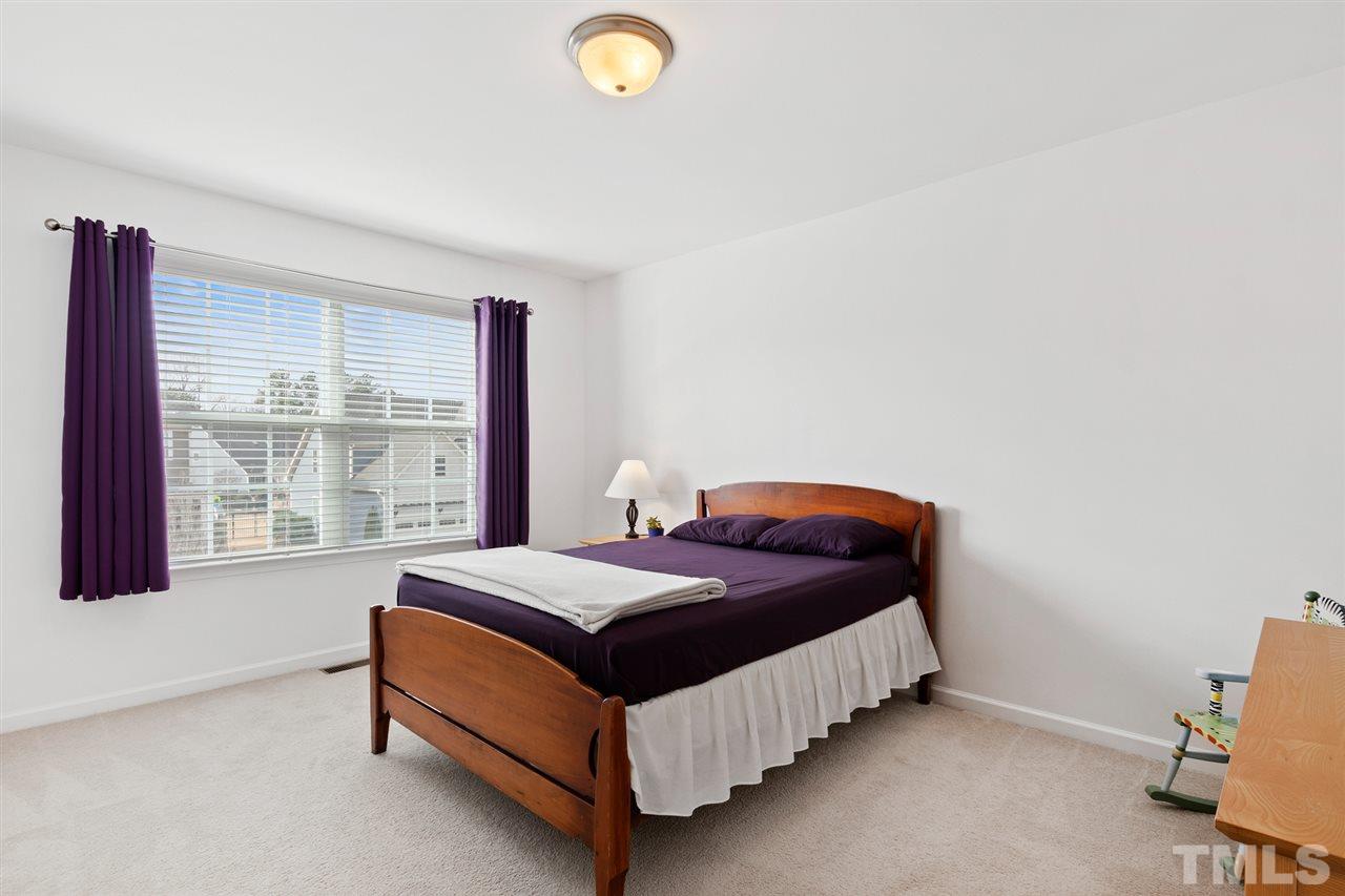 1013 Traditions Meadow Drive Wake Forest, NC 27587 - Photo 24 of 30 a bed sitting in a bedroom next to a window