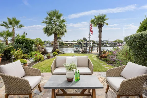 a view of a patio with couches and a potted plant on a table and chairs