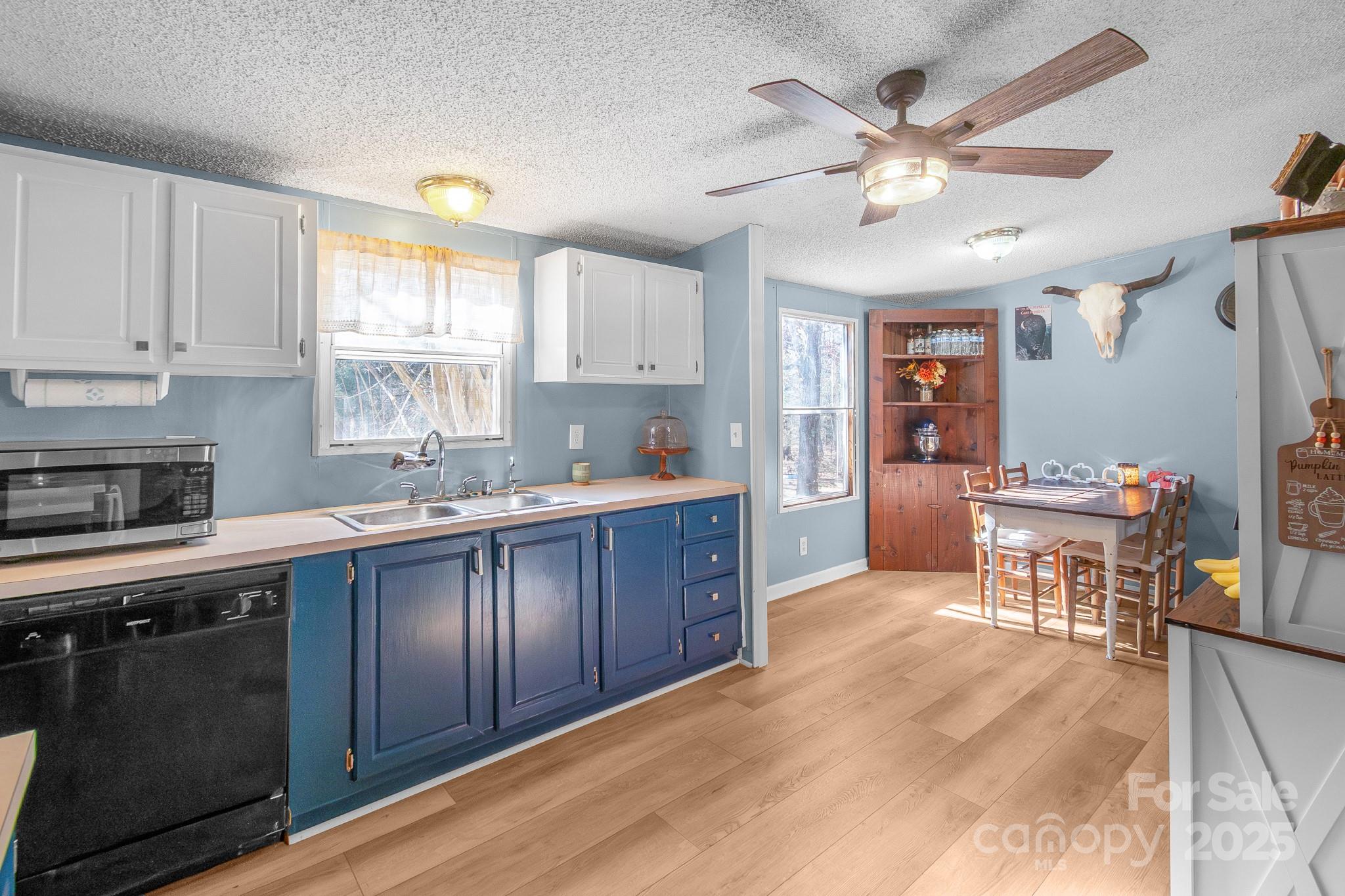 2214 Sojourn Road Marshville, NC 28103 - Photo 17 of 48 a kitchen with stainless steel appliances kitchen island granite countertop a refrigerator a sink dishwasher a dining table and chairs with wooden floor