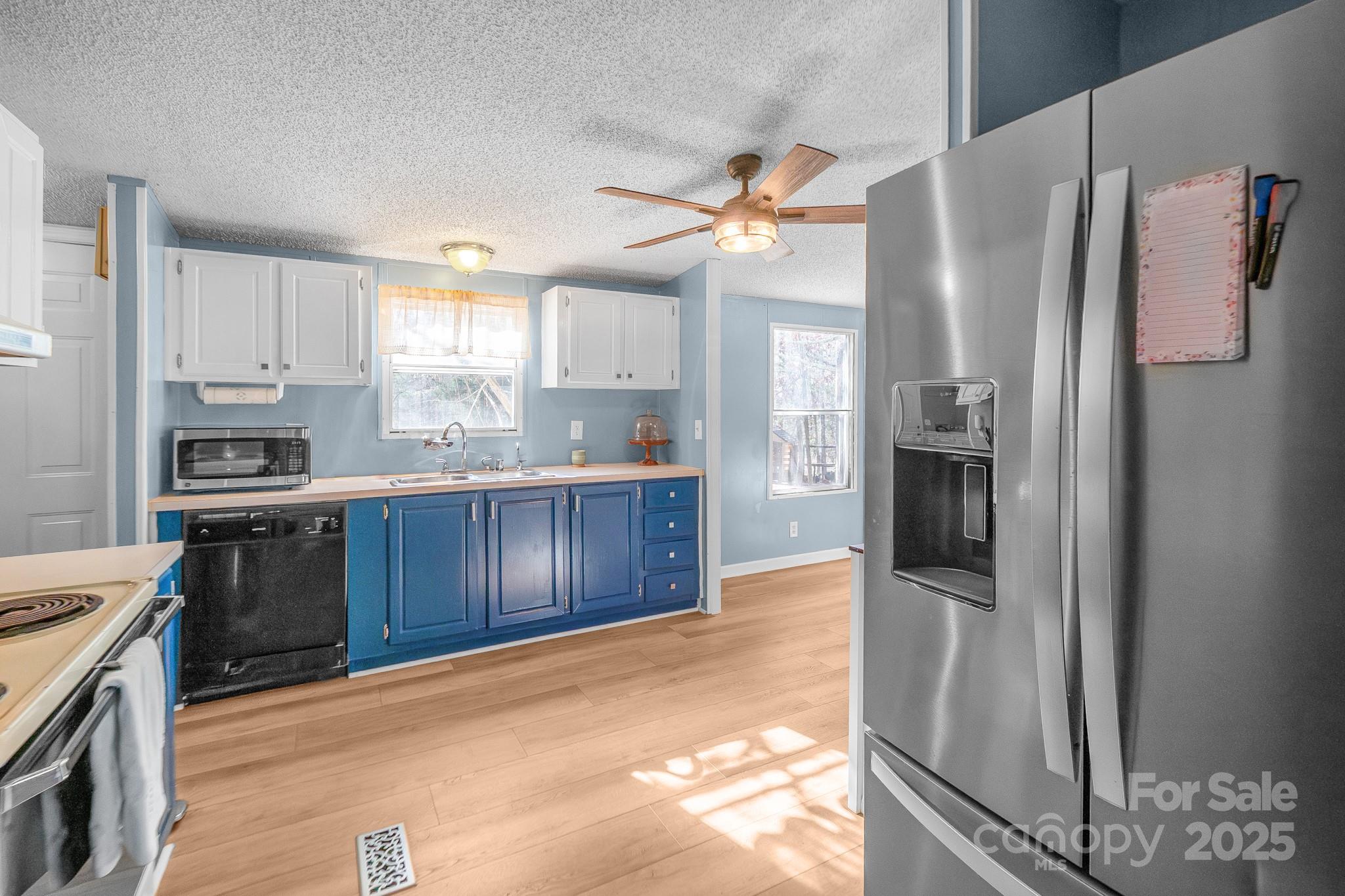 2214 Sojourn Road Marshville, NC 28103 - Photo 18 of 48 a kitchen with stainless steel appliances granite countertop a refrigerator a stove and a sink with wooden floor