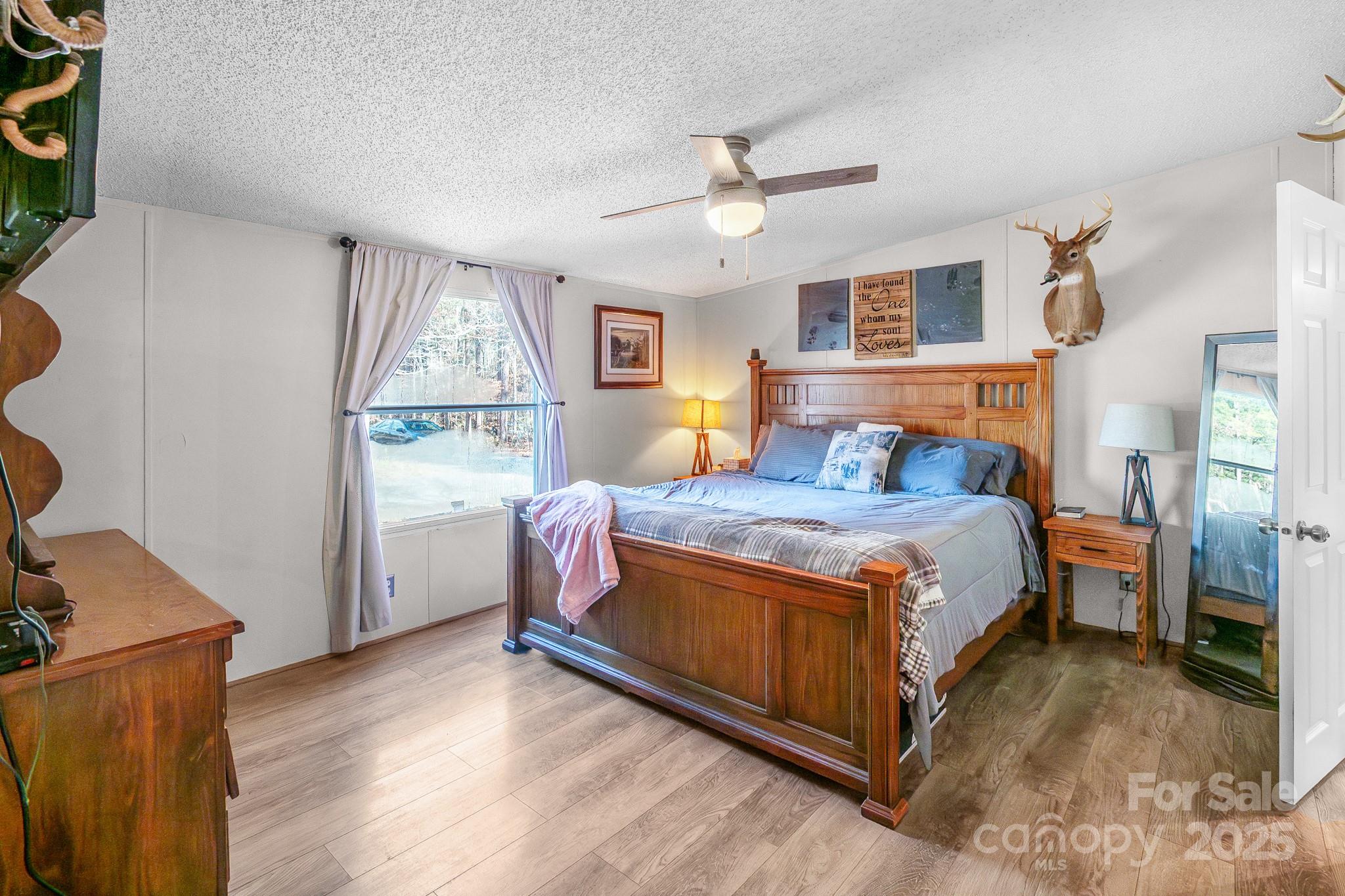 2214 Sojourn Road Marshville, NC 28103 - Photo 4 of 48 a bedroom with a large bed a chandelier and a window