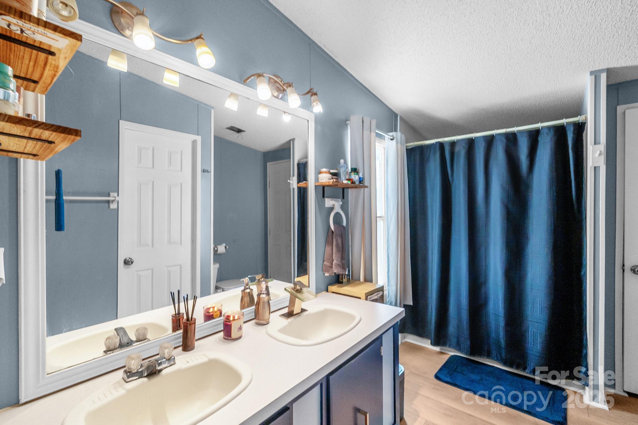 2214 Sojourn Road Marshville, NC 28103 - Photo 6 of 48 a bathroom with a sink a mirror and a shower