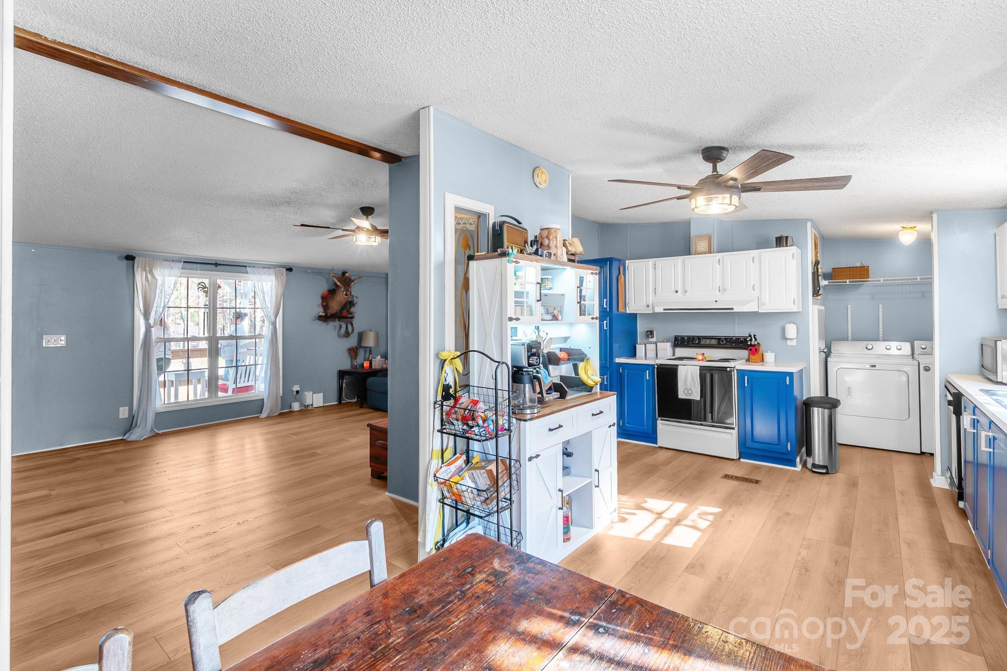 2214 Sojourn Road Marshville, NC 28103 - Photo 8 of 48 a living room with stainless steel appliances furniture a chandelier and a kitchen view