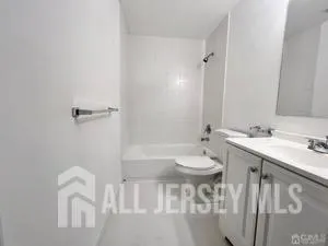 a bathroom with a sink two mirror and a bathtub