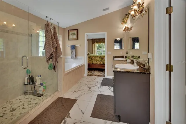 a bedroom with a large bed and a chandelier