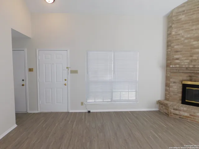 an empty room with wooden floor and fireplace