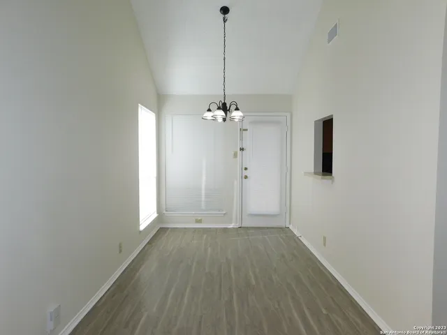 a view of a room with wooden floor and chandelier