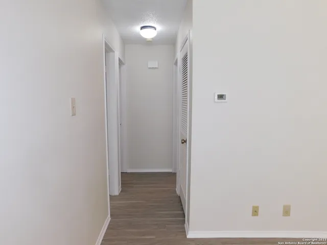 a view of a hallway with wooden floor