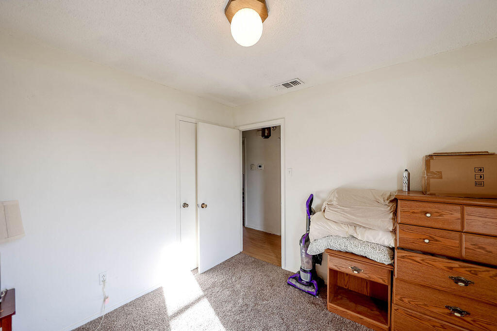 6001 14th Street Lubbock, TX 79416 - Photo 21 of 31 a bedroom with a bed and a mirror