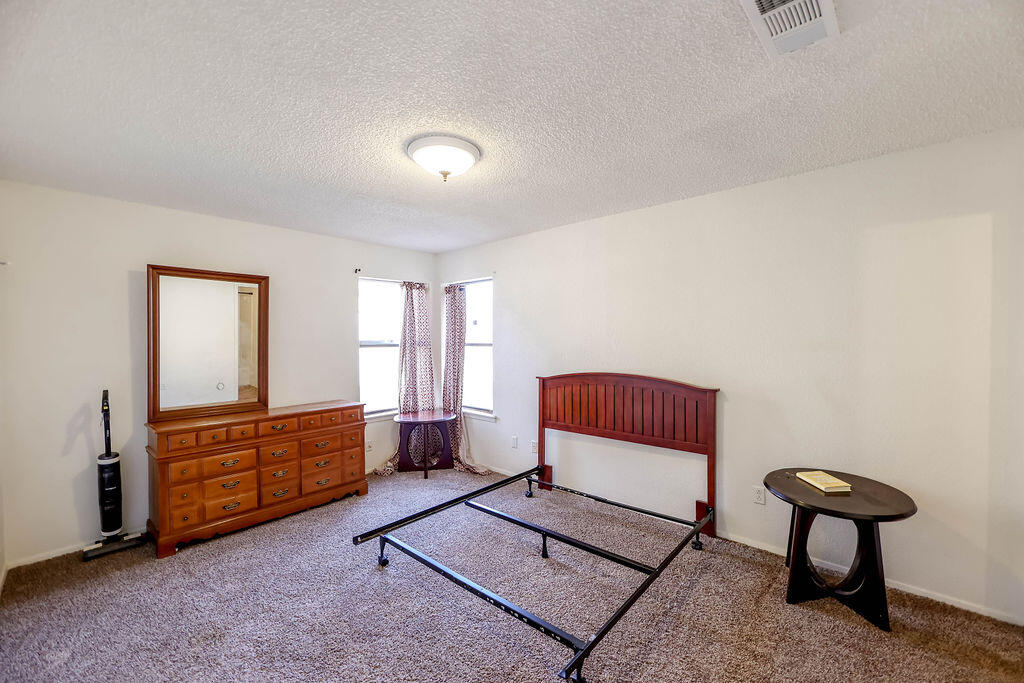 6001 14th Street Lubbock, TX 79416 - Photo 24 of 31 a bedroom with a bed and a cabinet