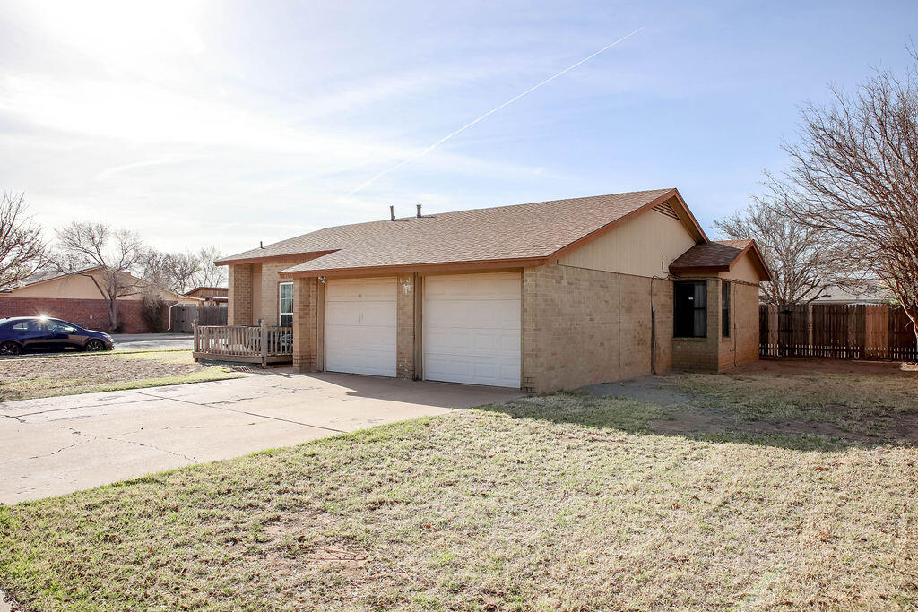 6001 14th Street Lubbock, TX 79416 - Photo 4 of 31 a view of a house with a yard and garage