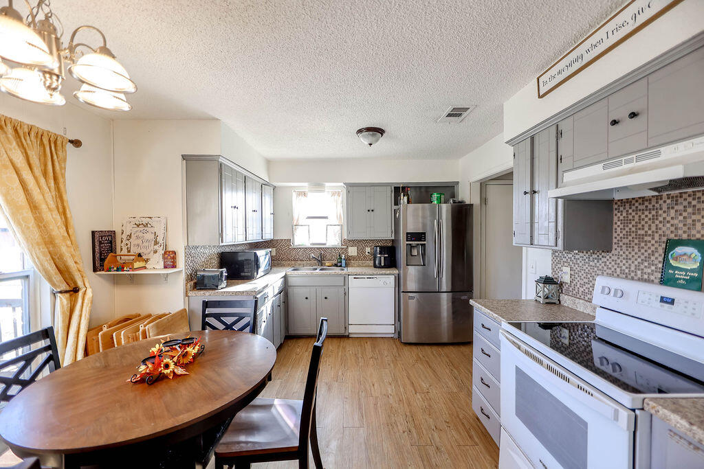 6001 14th Street Lubbock, TX 79416 - Photo 8 of 31 a large kitchen with a table chairs stove and refrigerator