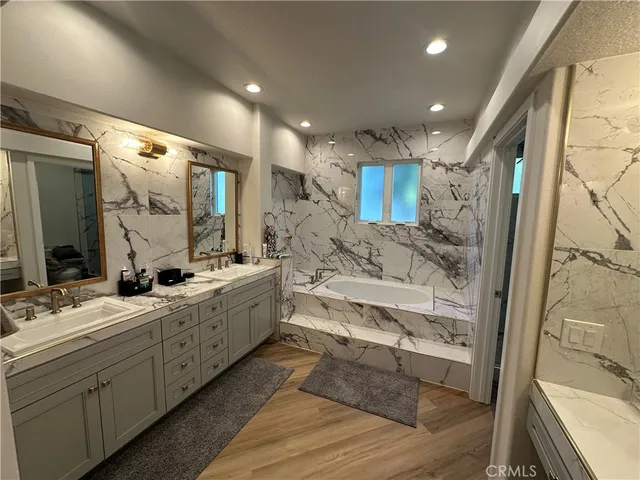 a large bathroom with a double vanity sink a mirror and a shower