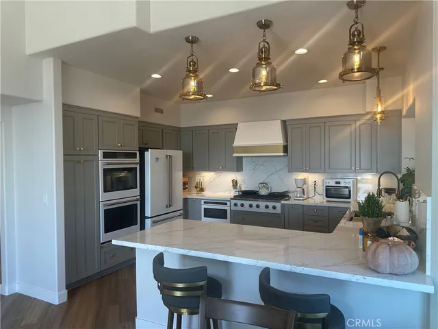 a kitchen with kitchen island a large counter top space appliances and cabinets