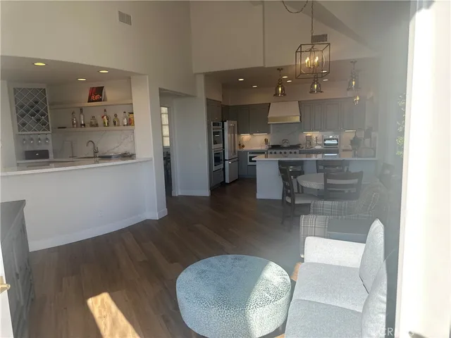 a kitchen with stainless steel appliances wooden floor dining table and chairs