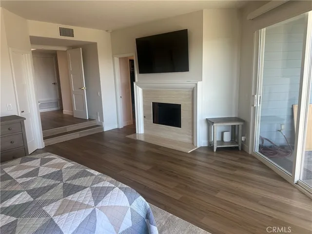 a view of a livingroom with wooden floor and a fireplace