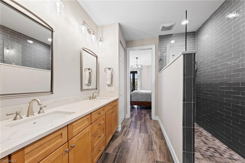 9076 Rialto Street, Unit 6204 Naples, FL 34113 - Photo 17 of 50 Double vanity with brushed nickel fixtures and quartz countertops. NEW QUARTZ COUNTERS (2018), NEW SHOWER REMODEL (2018), NEW MIRRORS (2018), NEW TILE FLOOR (2018)
