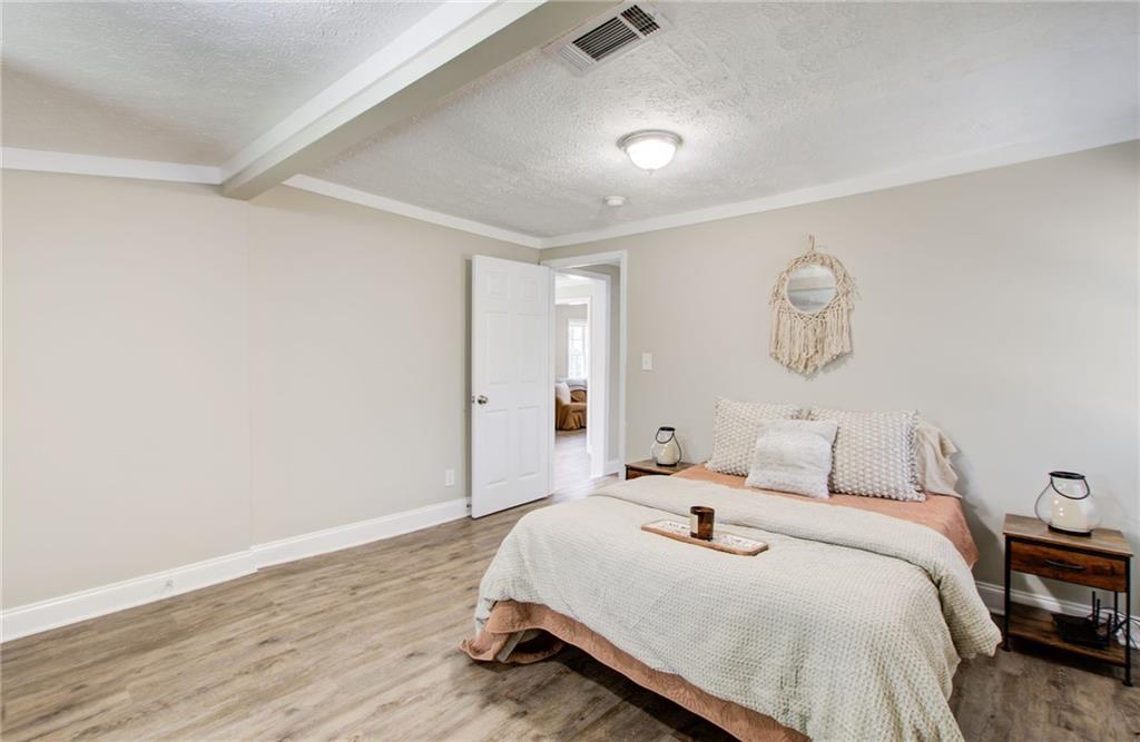 411 Ash Street Monroe, GA 30655 - Photo 18 of 36 a bedroom with a bed and wooden floor