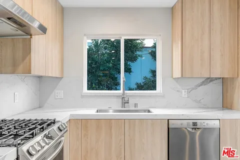 a kitchen with stainless steel appliances a sink stove and cabinets