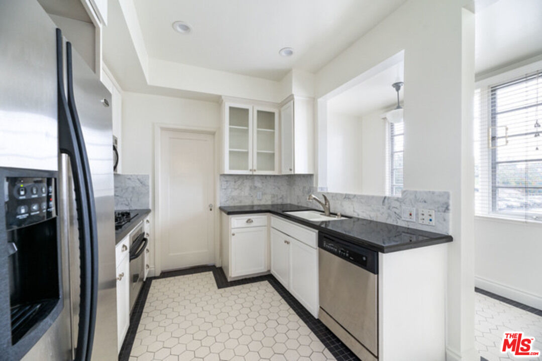 9237 Doheny Road West Hollywood, CA 90069 - Photo 6 of 14 a kitchen with a sink stove and refrigerator