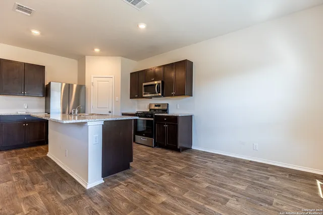 a kitchen with a refrigerator and a stove top oven