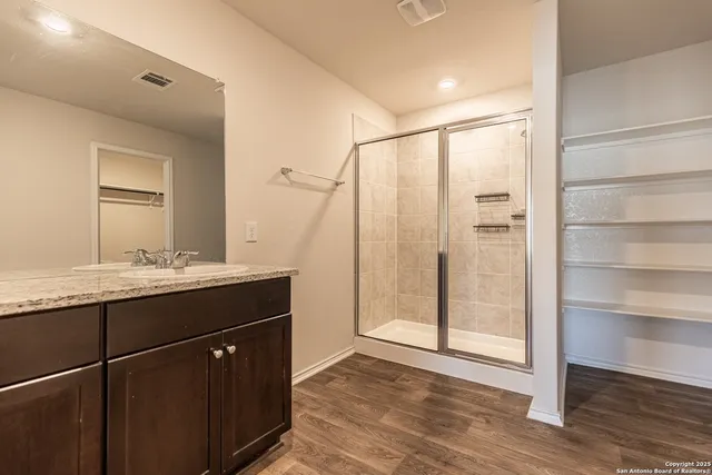 a bathroom with a shower sink and mirror