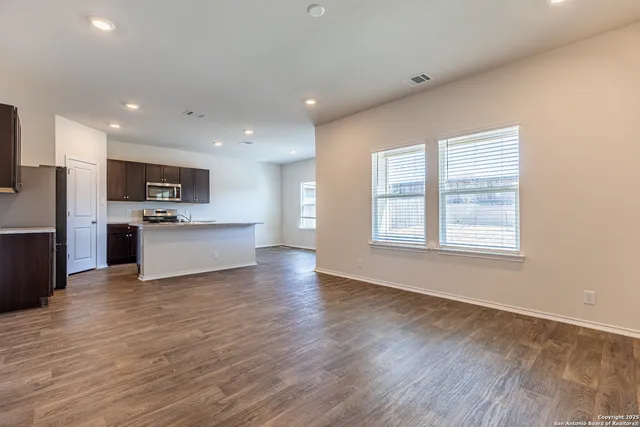 a view of kitchen with granite countertop cabinets and refrigerator