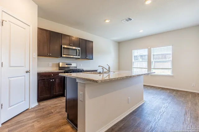 a kitchen with stainless steel appliances granite countertop a sink stove and refrigerator