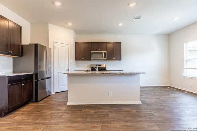 a view of kitchen with stainless steel appliances granite countertop a stove a refrigerator and a microwave