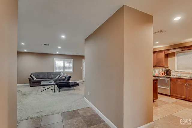 a living room with furniture and a refrigerator