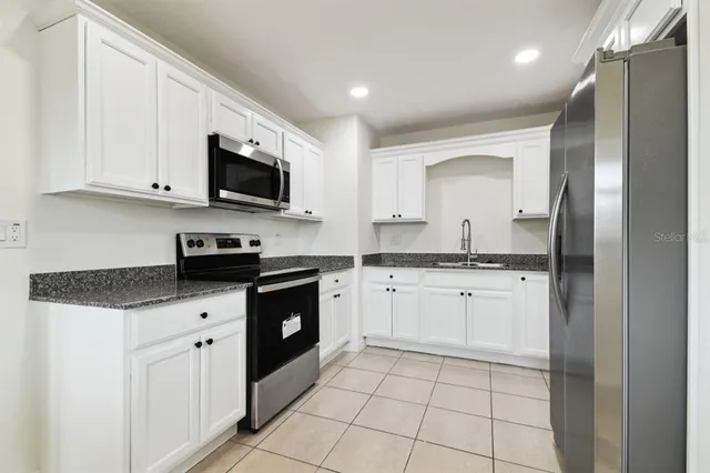 a kitchen with stainless steel appliances granite countertop a sink and a stove