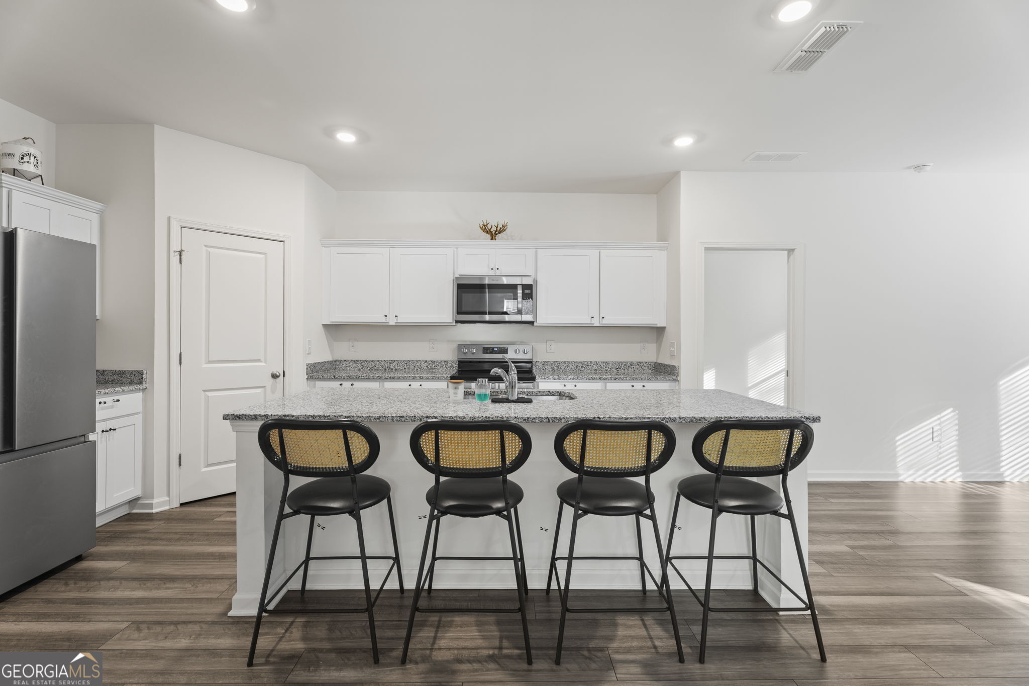 119 Bantry Way Locust Grove, GA 30248 - Photo 5 of 34 a kitchen with granite countertop a dining table chairs refrigerator and cabinets