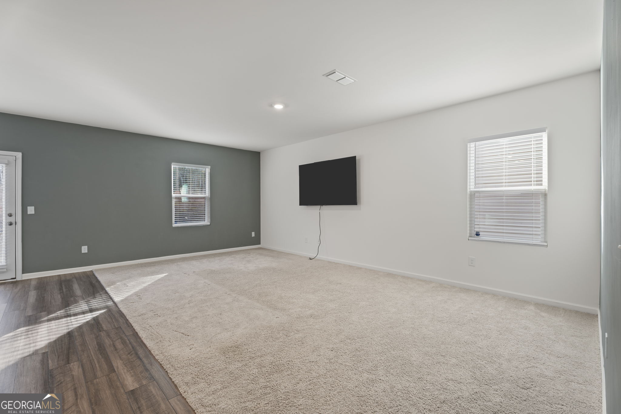 119 Bantry Way Locust Grove, GA 30248 - Photo 9 of 34 a view of an empty room with a window and a flat screen tv