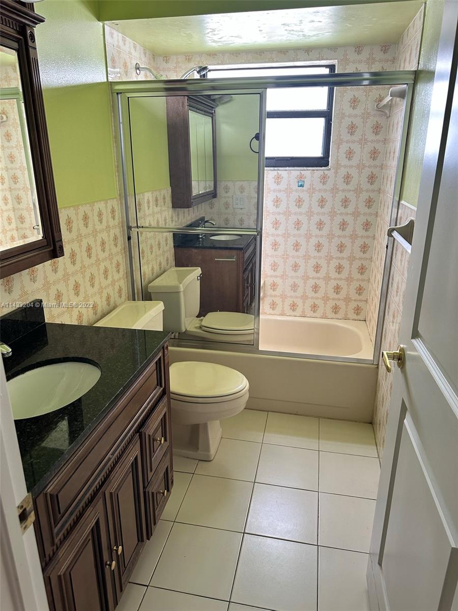 9110 Southwest 9th Terrace, Unit 9110 Miami, FL 33174 - Photo 13 of 17 a bathroom with a granite countertop toilet sink and mirror