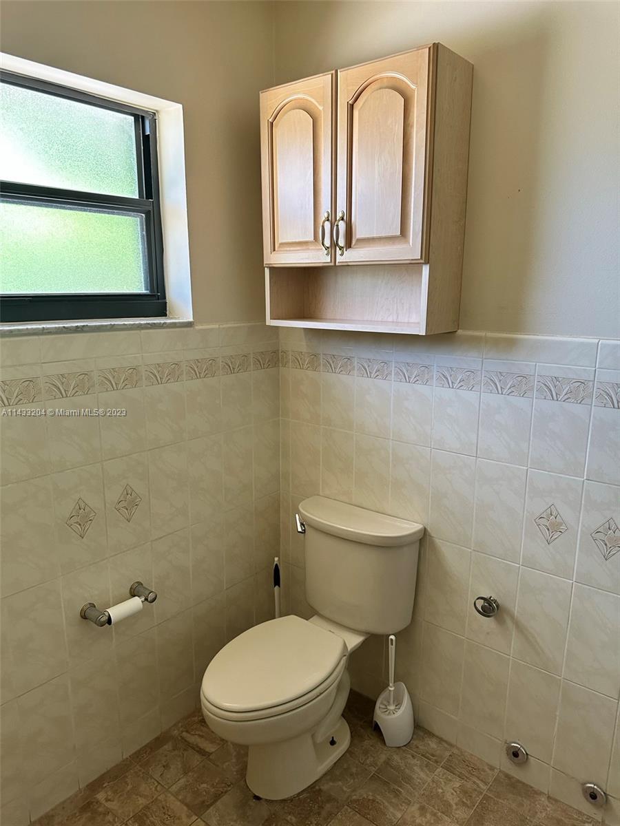 9110 Southwest 9th Terrace, Unit 9110 Miami, FL 33174 - Photo 15 of 17 a bathroom with a toilet sink and mirror