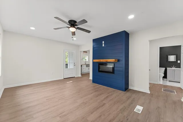 a view of empty room with wooden floor and ceiling fan